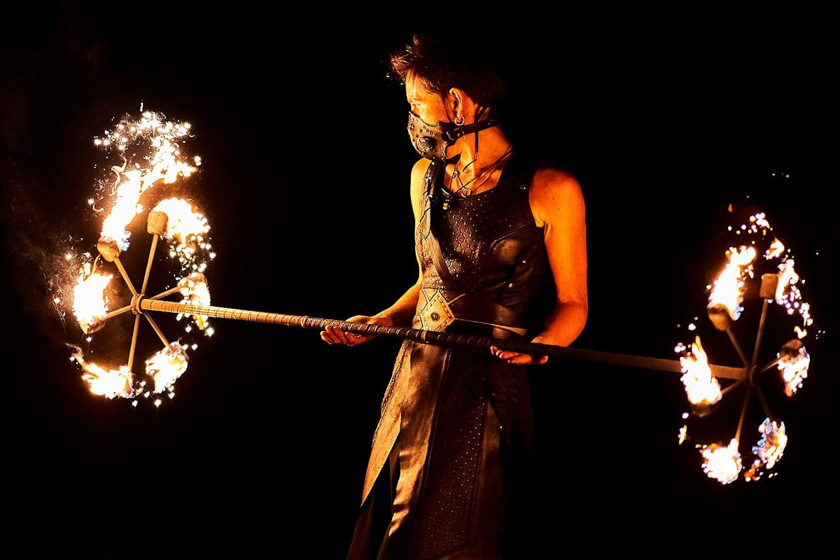Animation médiévale avec jonglerie de feu et cracheur de flammes lors d'un festival en Normandie.